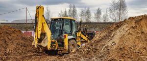 Excavator is working on a construction site against a cloudy sky