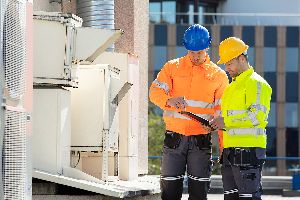 Why Regular Environmental Assessments Are A Smart Investment For Businesses 1 Two Environmental Assessors Check A Air Conditioning Unit.